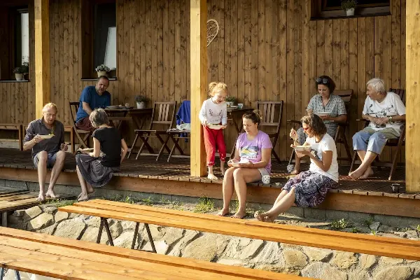 Skupina lidí na terase s hudební dovolenou a terapeutickými nástroji.