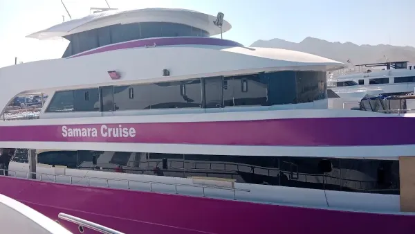 Loď Samara Cruise s růžovým pruhem v přístavu.