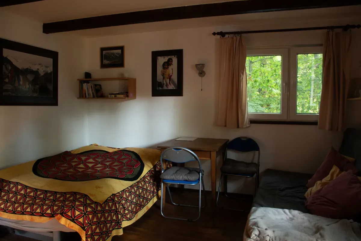 Ložnice s dvěma lůžky a černobílými obrázky na stěně.