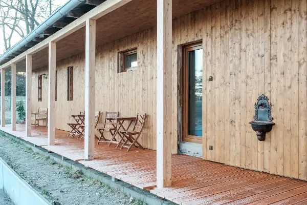 Relaxační prostor s dřevěnou fasádou a terasou pro hudební terapii v Roztěži.