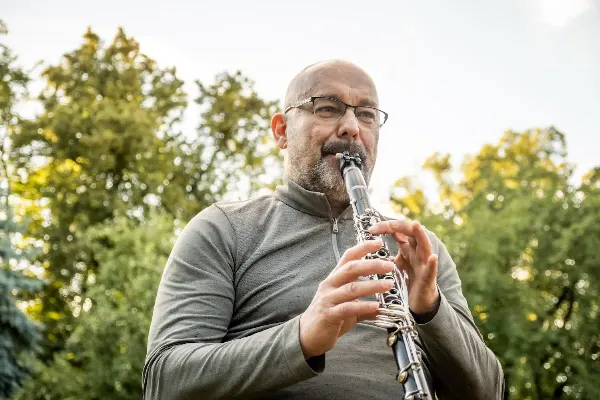 Muž hrající na klarinet v přírodě - relaxační zvuková terapie