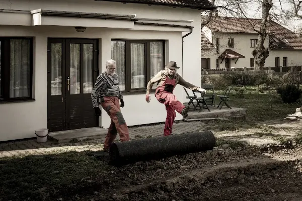 Dvě osoby pokládají geotextýlii pro budoucí labyrint.