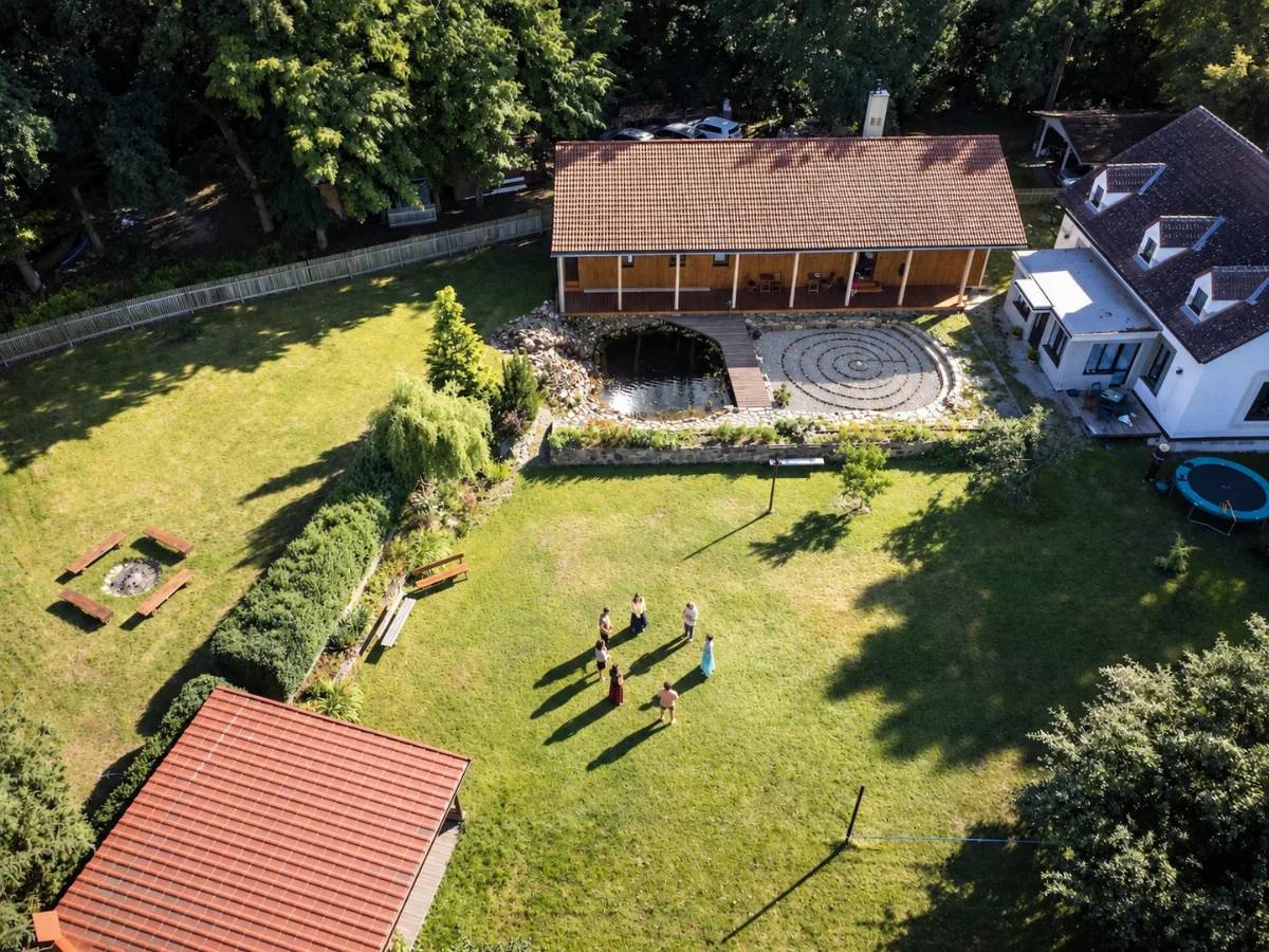 Letecký pohled na areál Dajány se stodolou a jezírkem.