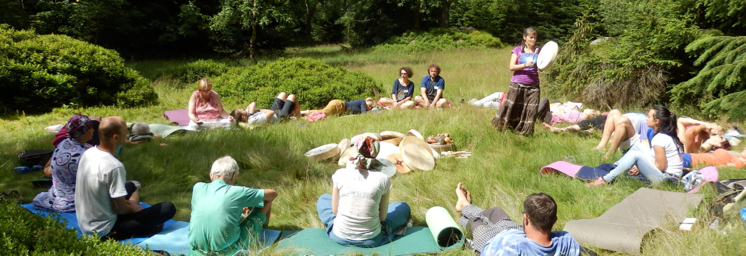 Jana Čadová vede muzikoterapeutický seminář v přírodě v kruhu účastníků.